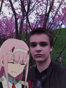 a man and a girl are posing for a picture in front of a tree with pink blossoms