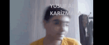 a blurry picture of a boy 's face with the name yusuf ab karizmaa written on the bottom