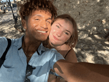 a man and a woman are posing for a selfie and the man is wearing a blue polo shirt