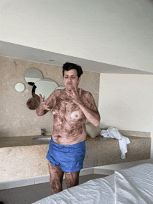 a man in blue shorts is standing in front of a sink and mirror