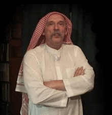 a man wearing a white shirt and a red and white scarf around his head .