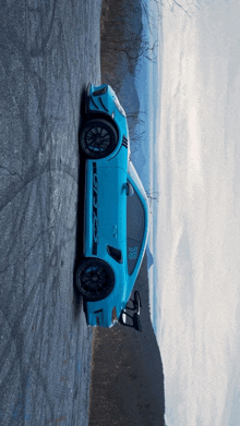 a blue porsche 911 gt3 is parked on the side of the road