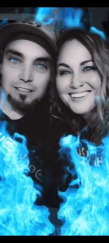 a man and a woman are standing next to each other with blue flames behind them