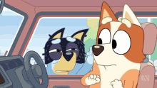 two cartoon dogs are sitting in a car with the letters abc on the seat back