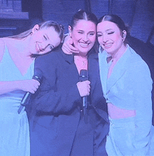 three women are posing for a picture while one woman holds a microphone