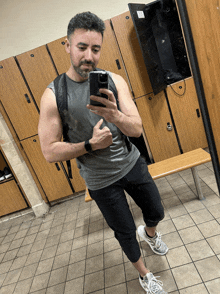 a man is taking a selfie in a locker room