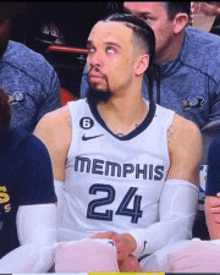 a basketball player wearing a memphis jersey is sitting in the stands