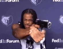 a man is holding a gun in front of fedex forum logos