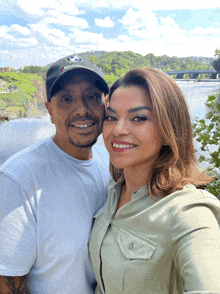 a man wearing a bmw hat is posing for a picture with a woman