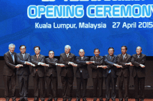 a group of men standing in front of a sign that says opening ceremony