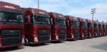 a row of red ford trucks with akgul written on the side