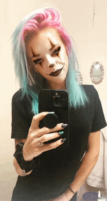 a woman with a clown makeup on her face takes a selfie