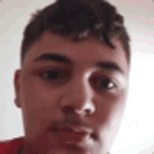 a close up of a man 's face with a red shirt on and a white background .