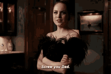 a woman in a black dress is standing in a room with her arms crossed and says `` screw you dad . ''