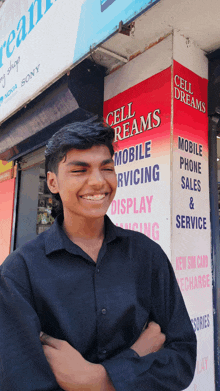 a young man smiles in front of a cell dreams sign