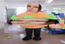 a woman is wearing a hamburger costume with a face on it