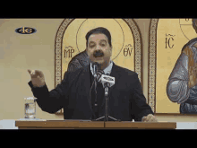 a man in a suit and tie is standing at a podium giving a speech .