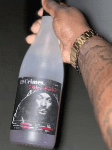 a man is holding a bottle of 19 crimes cali ross