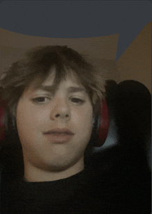 a boy wearing headphones looks at the camera with a speech bubble above his head