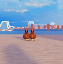 two chickens standing on a sandy beach in front of an inflatable water park