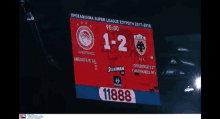 a scoreboard shows the score of 1-2 between a.e.c. and a.g.k.