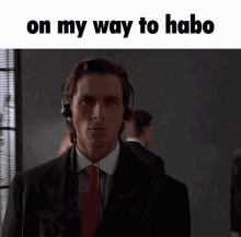 a man in a suit and tie is wearing headphones and the caption on my way to habo