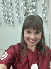 a woman wearing a red jersey with the number 20 on it smiles