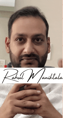 a man with a beard is behind a sign that says rahul manikala