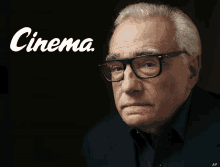 a man wearing glasses stands in front of a black background that says cinema