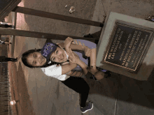 two girls are hugging in front of a plaque that says the welcome to las vegas sign