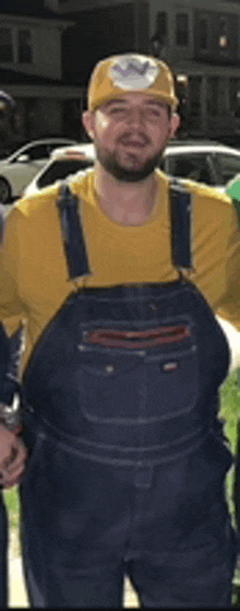 a man in overalls is wearing a yellow shirt