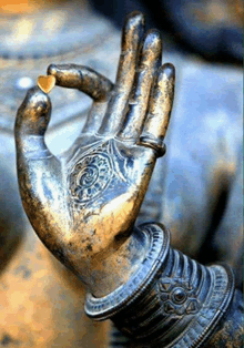 a close up of a statue of a hand with a ring on it