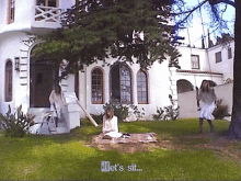 a woman sits on a blanket in front of a white house with the words " let 's sit " on the bottom