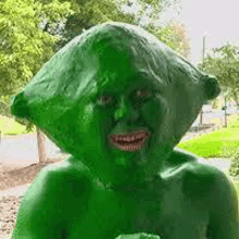 a statue of a person with a green face painted like a green bag .