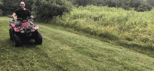 a man is riding an atv on a grassy hillside