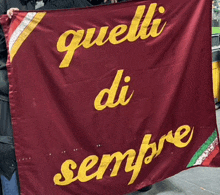 a person is holding a red flag that says quelli di sempre