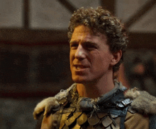 a man with curly hair wearing a fur collar and armor