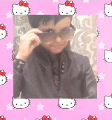 a boy wearing sunglasses is surrounded by hello kitty