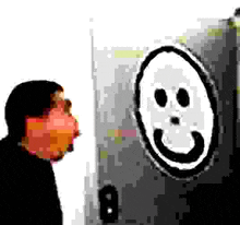 a man is looking at a smiley face drawing on a wall .