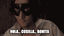 a man wearing a mask with the words hola cosilla bonita below him