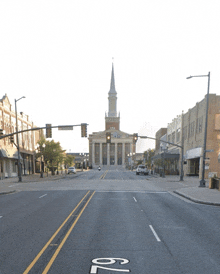 a street with a church in the background and a street sign that says 82