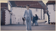 a man in a suit is walking down a street in front of a sign that says no left turns