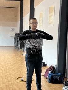 a man wearing boxing gloves stands in a room with a puma bag on the floor