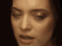 a close up of a woman 's face in a dark room