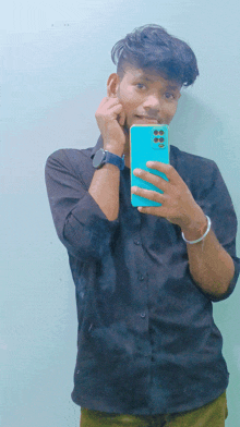 a young man in a black shirt takes a selfie with his phone