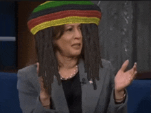 a woman wearing a bob marley hat with dreadlocks on her head