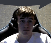 a man wearing headphones is sitting in a chair and looking at the camera