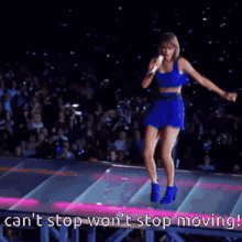 taylor swift is standing on a stage holding a microphone and singing into it .