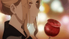 a close up of a girl looking at a red object