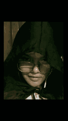 a girl wearing glasses and a hooded jacket